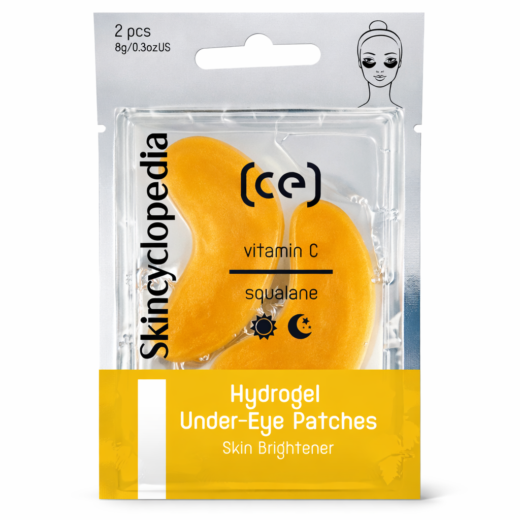 Verpackung für Hydrogel Augenpads mit Vitamin C und Squalan. Zwei goldene, tropfenförmige Pads sind in einer transparenten Hülle sichtbar. Die Packung ist gelb und silberfarben.