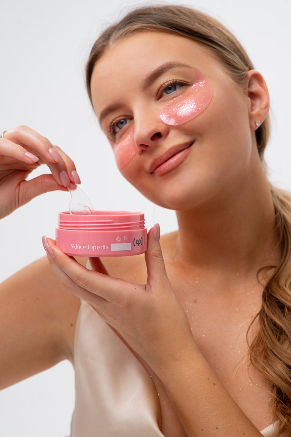 Frau mit Augenpatches. Sie hält eine Dose mit Collagen Augenpatches in der Hand.