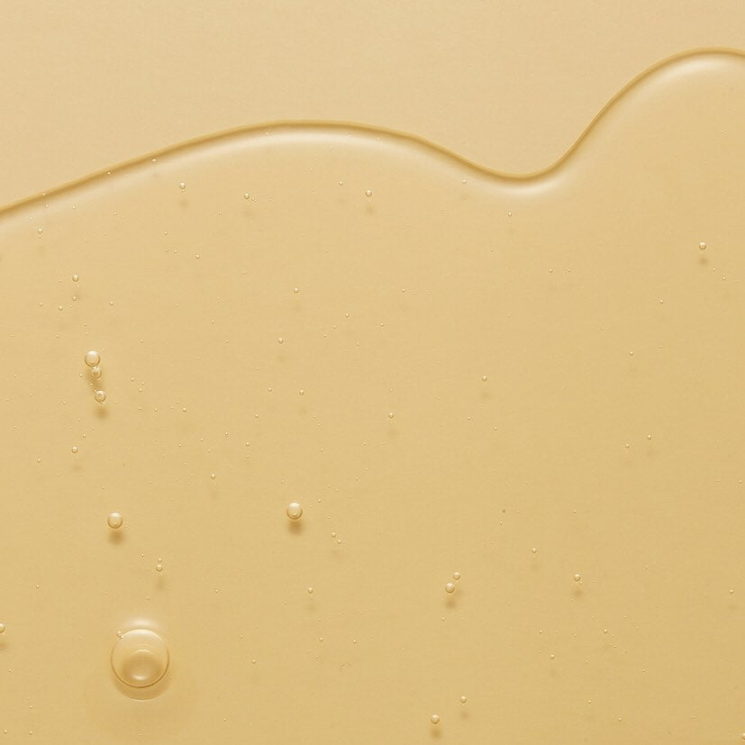 Nahaufnahme von flüssigem, hellem HIDEHERE Vita Elixir Serum mit kleinen Luftblasen.