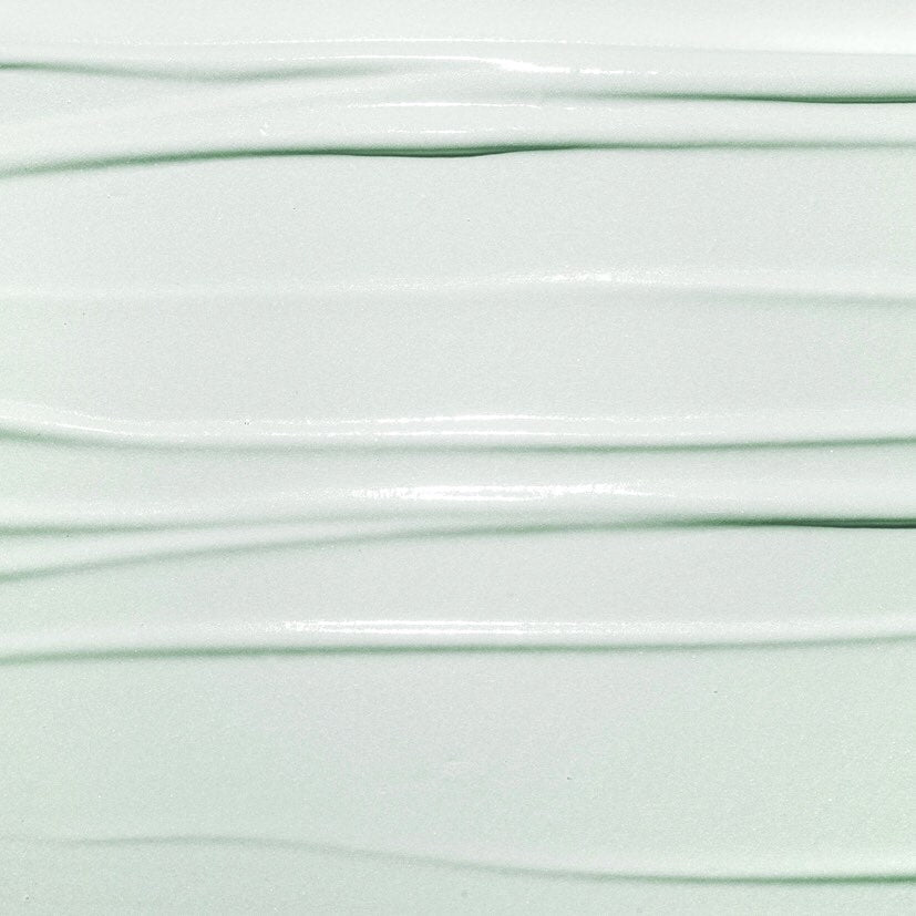 Nahaufnahme der Textur von HIDEHERE Cica Care Creme. Sanfte, waagerechte Linien in Pastellgrün.