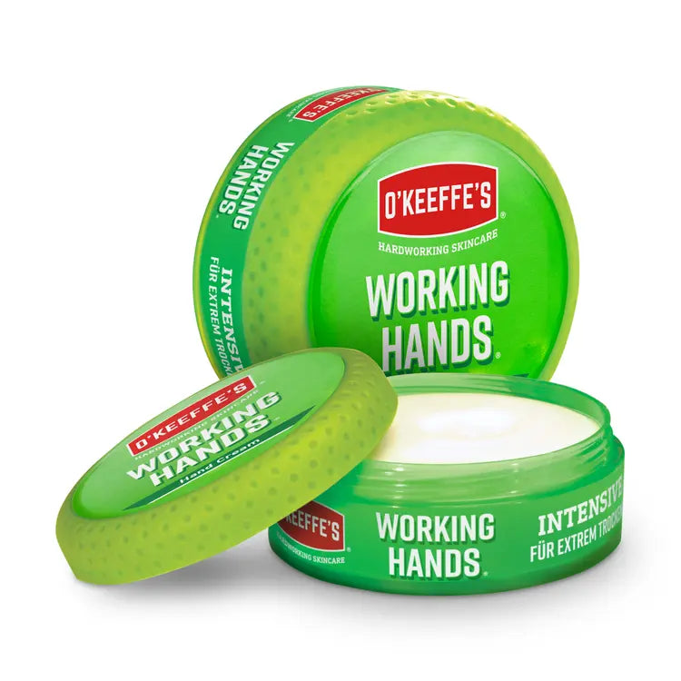 Geöffnete grüne Dose mit weißer Creme neben einer geschlossenen Dose der O'KEEFFE'S Working Hands Handcreme