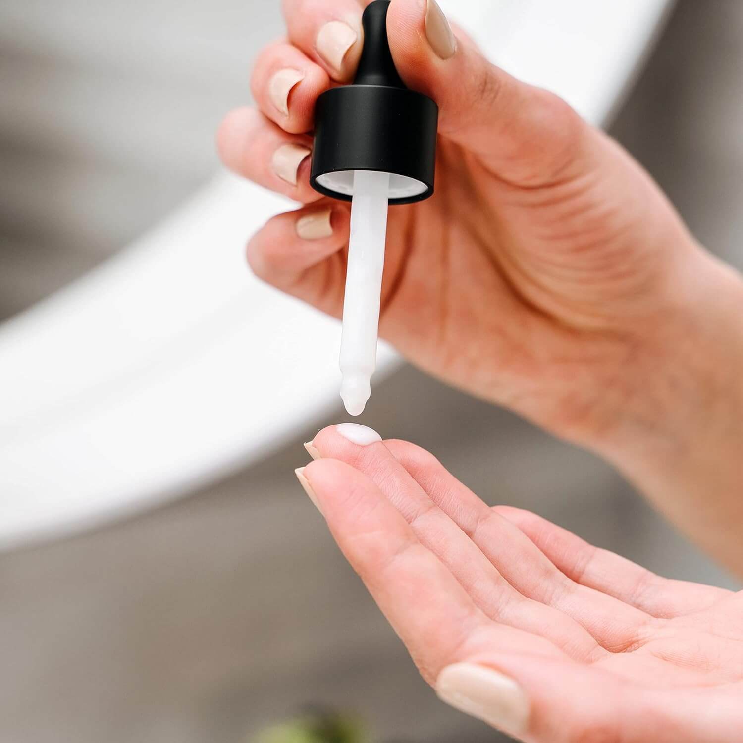 Hand mit Ceramide Serum Tropfen, zur Hautpflege und Stärkung der Hautbarriere.