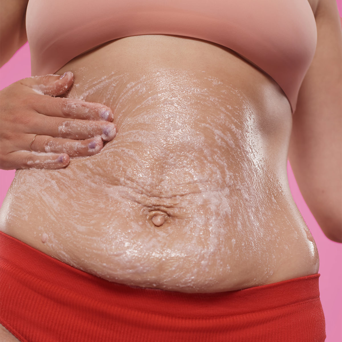 FRANK BODY Rosehip Body Scrub + Cleanser wird mit der Hand auf dem Bauch einmassiert