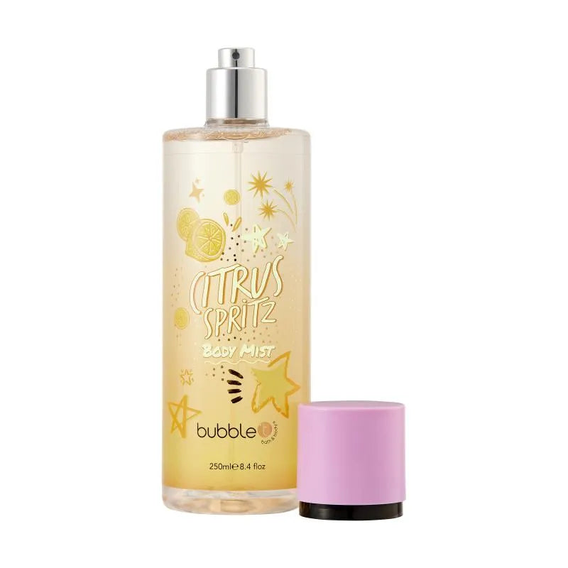 Eine Flasche mit "Citrus Spritz" Körpernebel steht neben ihrem rosa Deckel auf weißem Hintergrund. Die Flasche ist klar und hat eine silberne Düse. Gelbe Zitrusfrüchte und Sterne zieren die Vorderseite der Flasche.