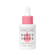 Weiße Flasche FRANK BODY Firming Booty Drops mit rosa Pipette und Tropfen-Design vor weißem Hintergrund