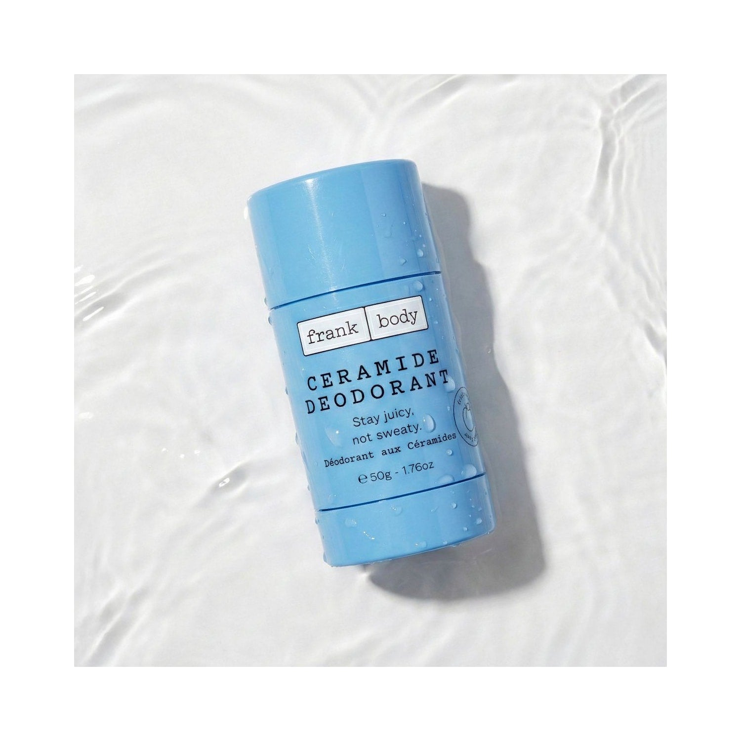 Hellblauer FRANK BODY Ceramide Deodorant Stick mit Wassertropfen auf einer klaren, sanft gewellten Wasseroberfläche