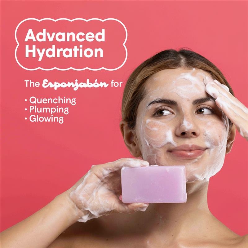 Eine Frau wäscht ihr Gesicht mit Seife. Sie hält ein lila Stück Seife in ihrer Hand. Schaum bedeckt ihr Gesicht. Im Hintergrund ist Text zu sehen, der für "Advanced Hydration" wirbt.