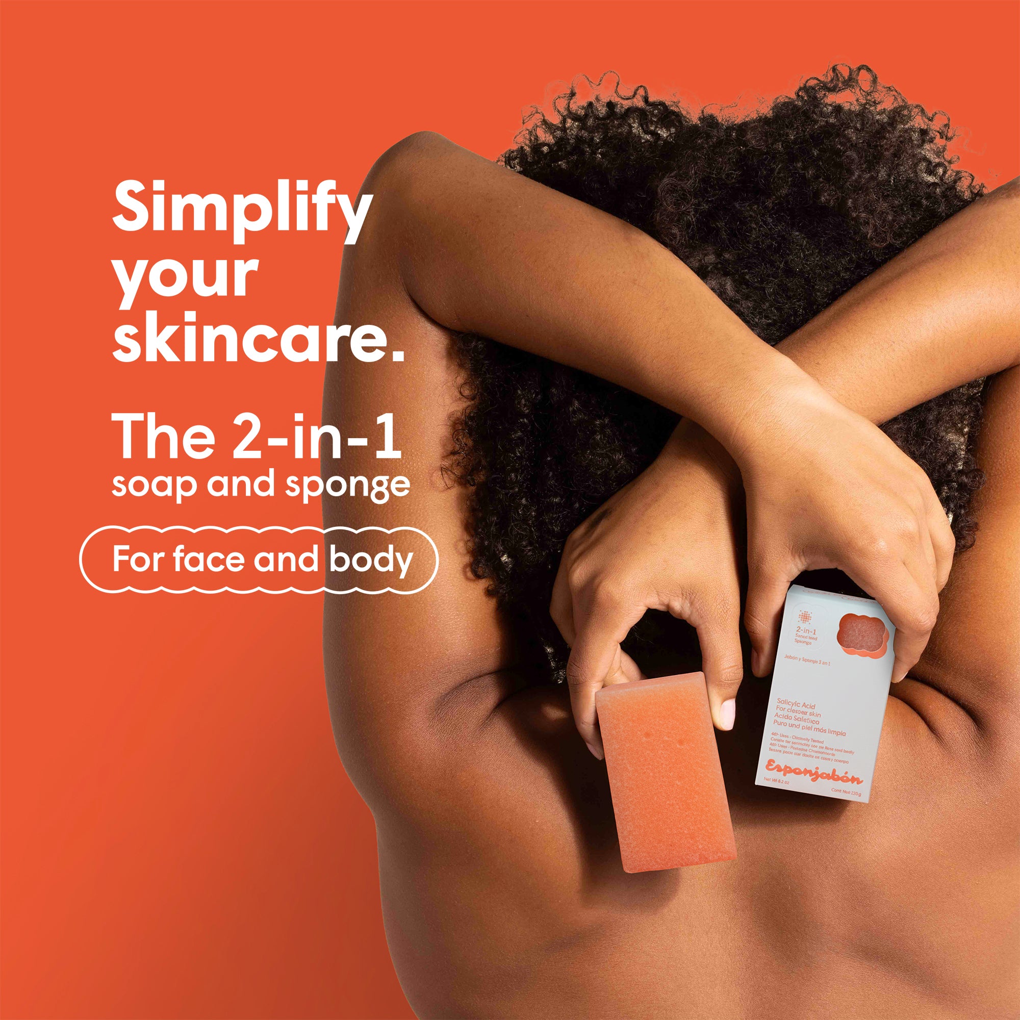 Person hält Esponjabon Salicylic Acid Seife-Schwamm-Kombi. Oranger Hintergrund, Text "Simplify your Skincare. The 2-in-1 soap and sponge."