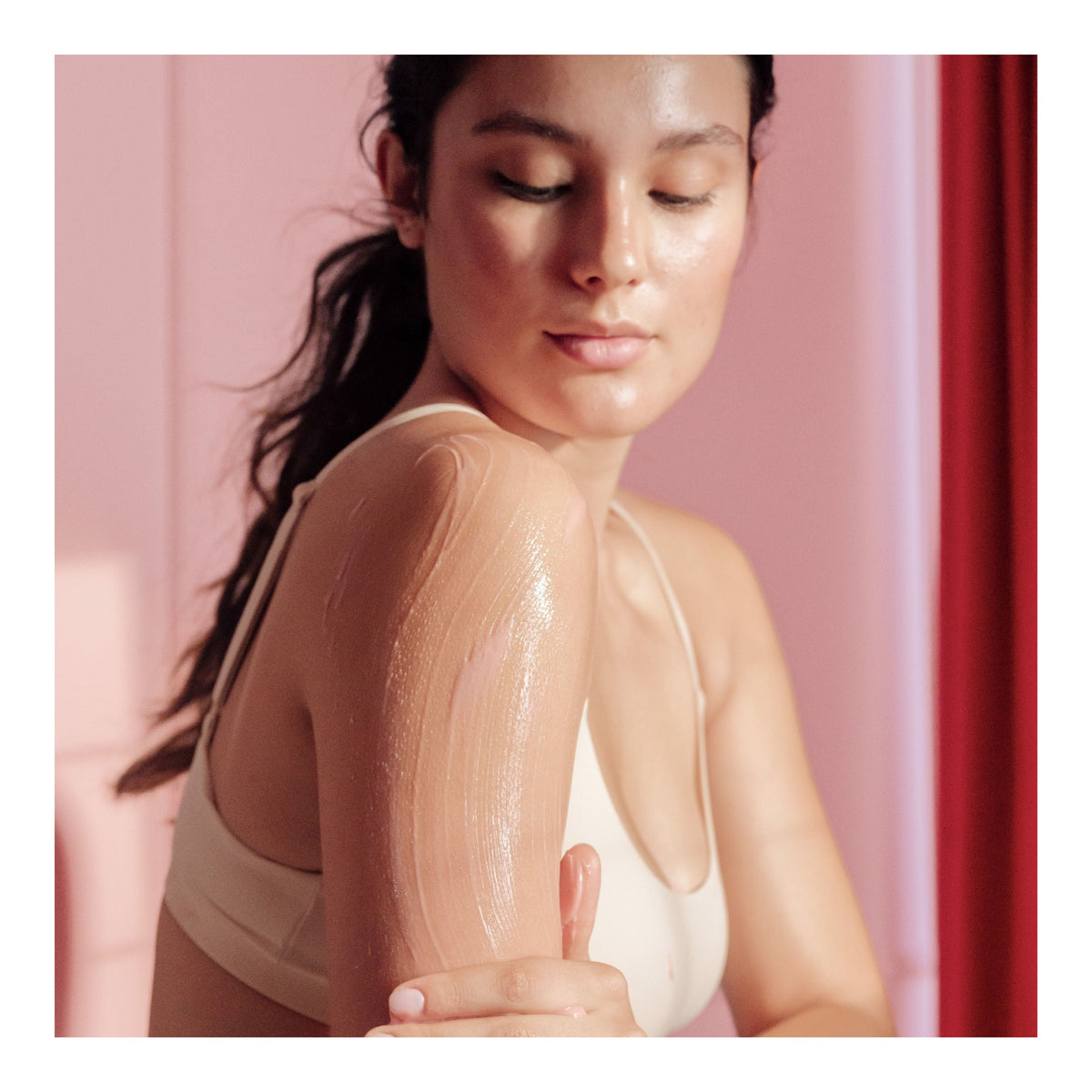 Une femme applique sur son bras le soin brillant issu du kit « Glazed Buns » de FRANK BODY