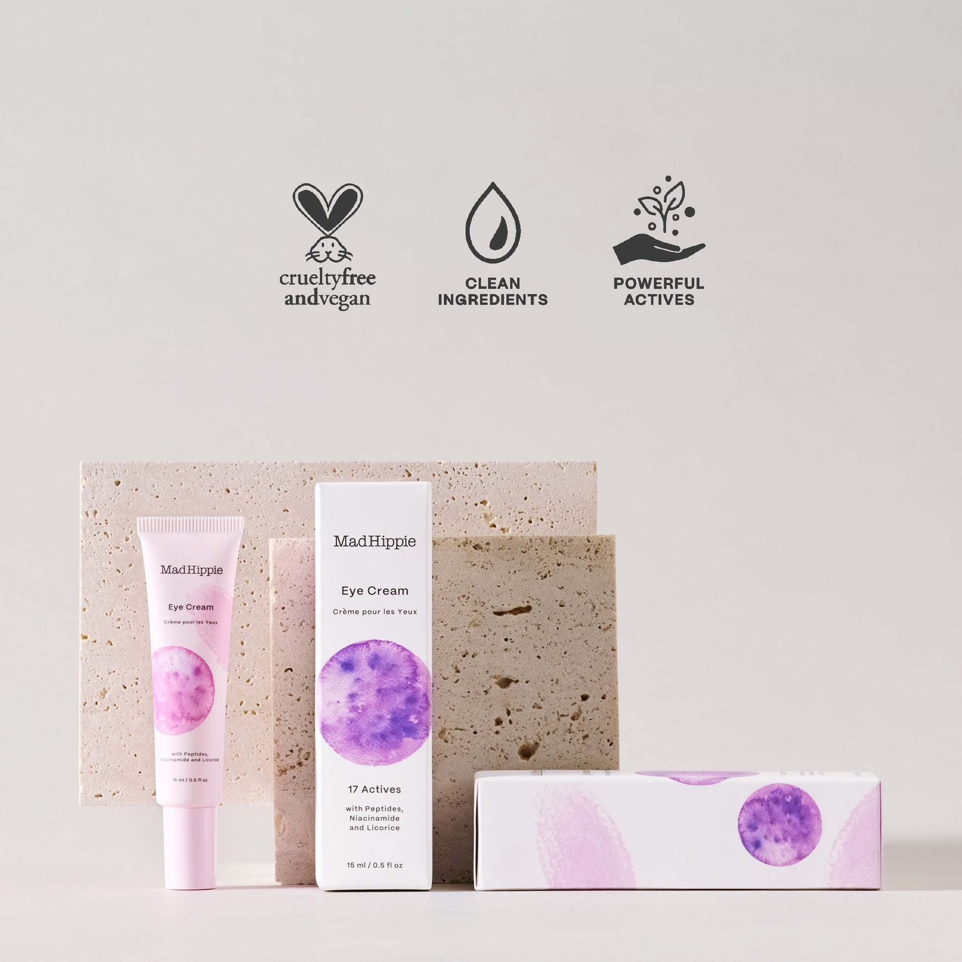 Tubo e embalagem do creme para os olhos MAD HIPPIE, em frente a elementos em pedra com três símbolos de cuidados e sustentabilidade