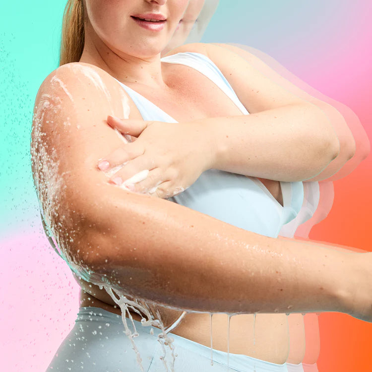 Eine Frau trägt schäumendes FRANK BODY Triple Acid Body Wash auf ihren Arm auf, während Wasser herabtropft
