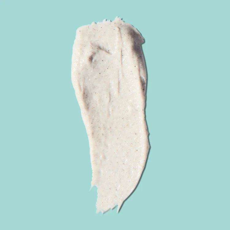 Cremige Texturprobe des FRANK BODY Glycolic Body Scrub mit feinen Peeling-Partikeln auf hellblauem Hintergrund
