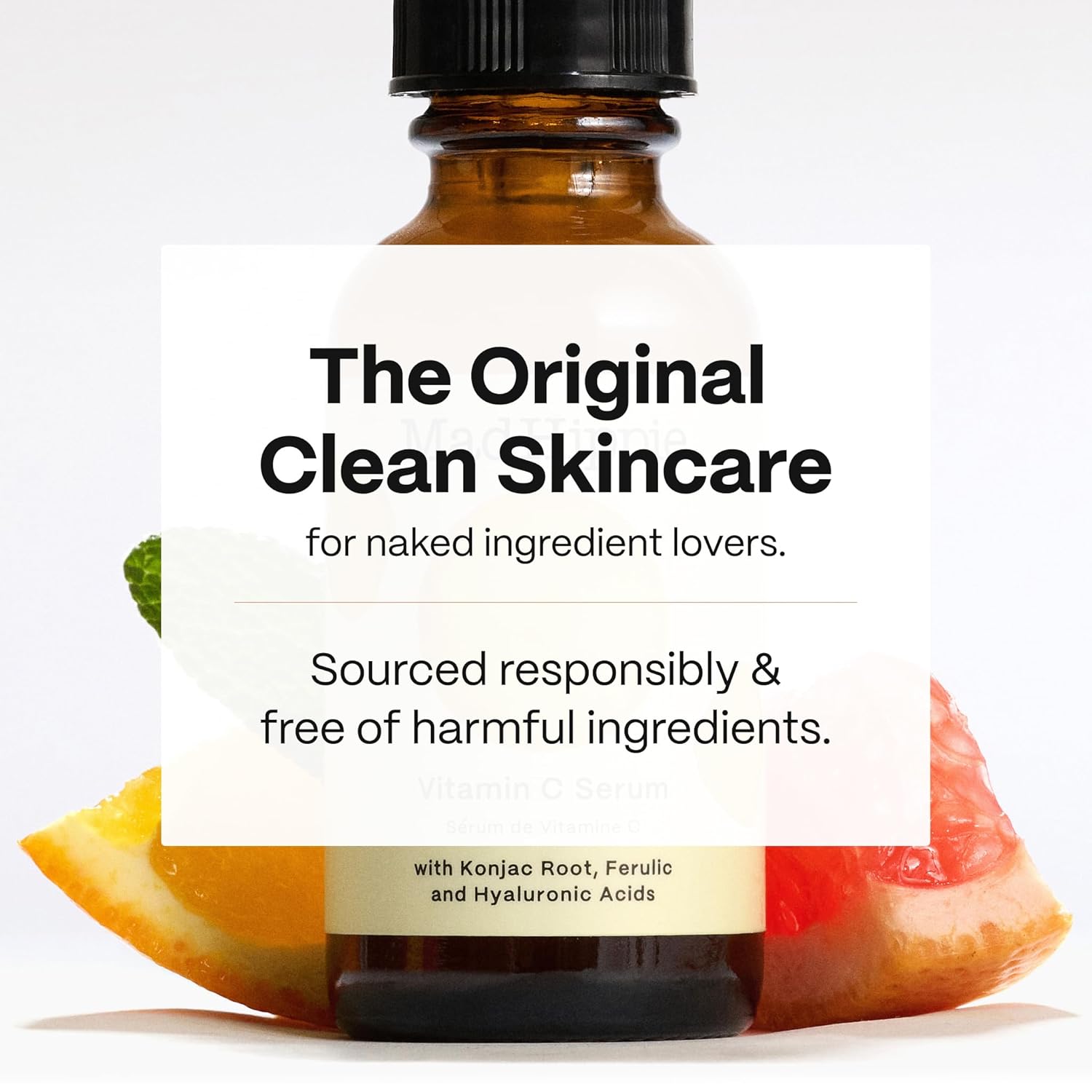 Frasco do sérum de vitamina C MAD HIPPIE rodeado por aromas frescos de laranja, toranja e menta sobre um fundo branco