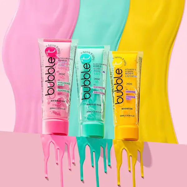 Drei Tuben Bubble-Bodylotion in Rosa, Türkis und Gelb stehen vor einem Hintergrund in denselben Farben. Aus dem Boden jeder Tube tropft Farbe.  Auf den Etiketten steht "Hydrator", "Protector" und "Booster".