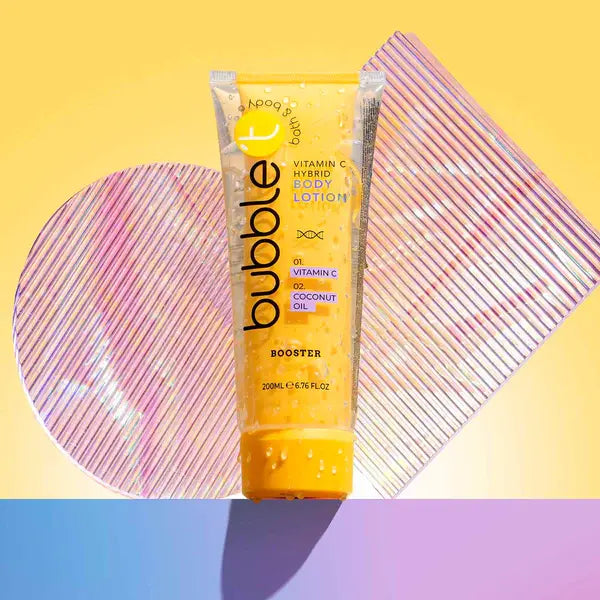 Vitamin-C-Körperlotion in "Blase" vor buntem Hintergrund. Geometrische Formen für Tiefe. Etikett zeigt Inhaltsstoffe: Vitamin C, Kokosnussöl. Größe: 200 ml.